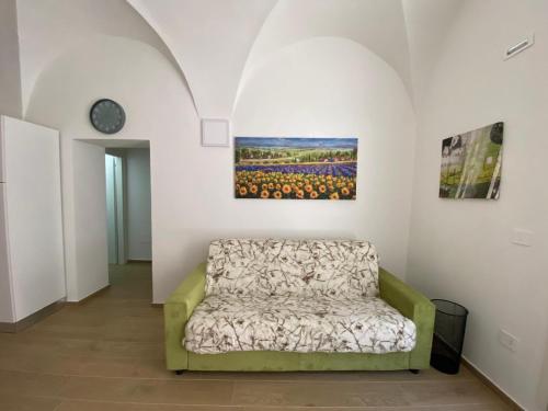 un canapé dans une pièce avec un tableau mural dans l'établissement La Casa sul Corso, à Ascoli Piceno