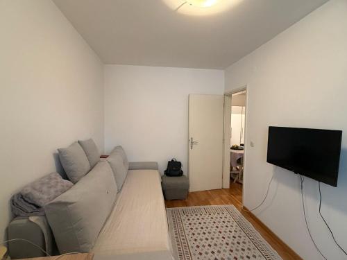 a living room with a couch and a flat screen tv at Alipasha's Apartment in Sarajevo