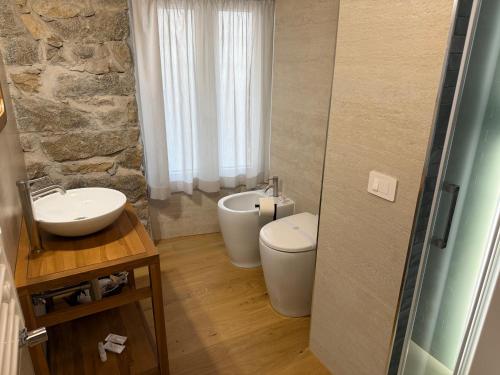 a bathroom with a sink and a toilet and a tub at Exoria Luxury Rooms & SPA in Nuoro