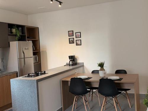 a kitchen with a table and chairs and a refrigerator at Hub cambui AP 62 in Campinas
