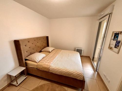 une chambre avec un lit dans une pièce dans l'établissement Cosy T2 neuf avec balcon Proche centre & plage, à Montpellier