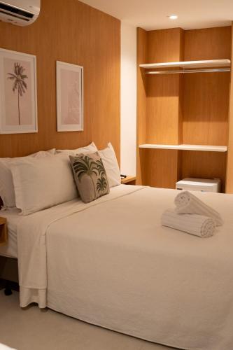 a bedroom with a large white bed and wooden walls at Arraial Concept Hotel in Arraial do Cabo