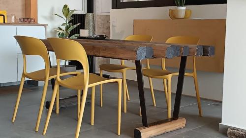 a wooden table with yellow chairs around it at "Naias"seaside residence in the port of Piraeus-entire holiday home in Piraeus