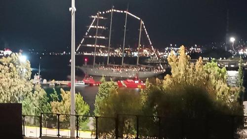a large ship is docked in a harbor at night at "Naias"seaside residence in the port of Piraeus-entire holiday home in Piraeus
