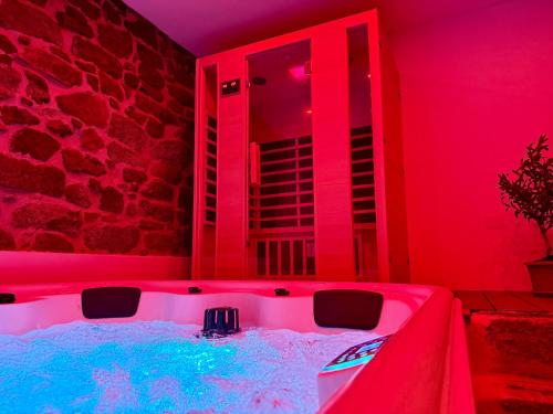 a hot tub in a room with red lights at Exoria Luxury Rooms & SPA in Nuoro