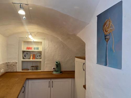 a kitchen with a painting of a mermaid on the wall at Glockenturm der Schlosskapelle von 1600 - Renaissance trifft auf die Gegenwart und beschert einen kunterbunten Urlaub für die ganze Familie mitten im Bayerischen Wald in Schwarzach