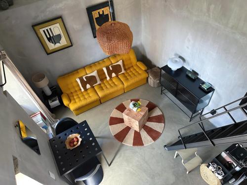 an overhead view of a living room with a yellow couch at THE L lodge, ocean view private garden Cottage in Ribeira Brava