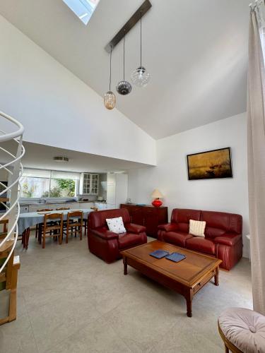 un salon avec un canapé rouge et une table dans l'établissement Spacieuse maison de 190 m2, jardin, la plage à 15min à pied - 6 personnes, à Les Sables-dʼOlonne