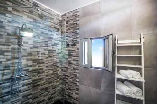 リンドスにあるCasaLindos Spitakiのバスルーム(シャワー、窓、タオル付)が備わります。