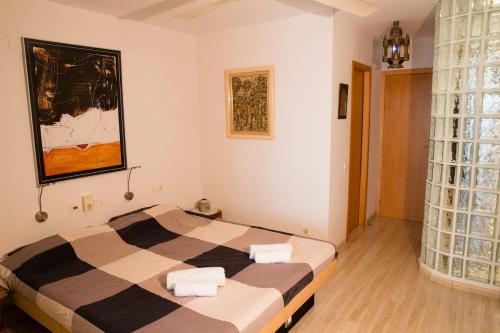 a bedroom with a bed with two towels on it at Stunning sea views over marina with swimming pool in Sitges