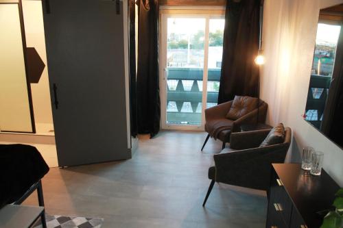 a living room with chairs and a door to a balcony at Bent Inn - LGBTQ Hotel in Las Vegas