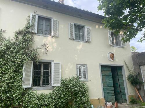 a white house with white shuttered windows at Windrose Casabianca in Collesalvetti