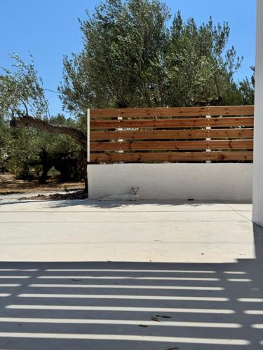 a wooden bench on the side of a building at Meltemi in Ferma