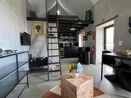 a living room with a loft bed and a table at THE L lodge, ocean view private garden Cottage in Ribeira Brava