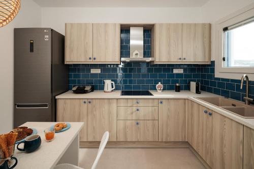 a kitchen with wooden cabinets and a black refrigerator at Silvina Beach House Naxos in Kastraki Naxou
