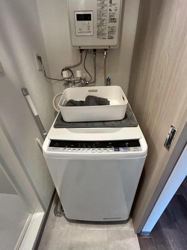 a kitchen with a stove and a microwave at Stisfy サティスファイ in Chitose