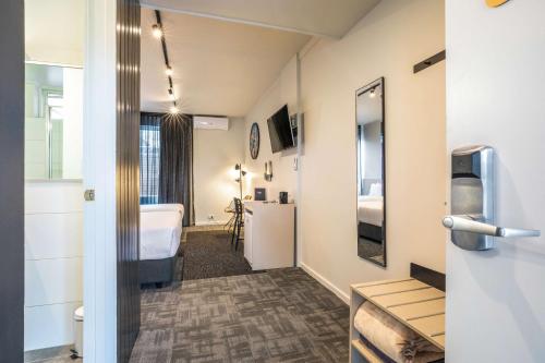 a room with a bathroom with a bed and a sink at Nightcap at Keysborough Hotel in Keysborough
