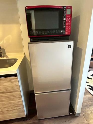 a microwave sitting on top of a refrigerator at Stisfy サティスファイ in Chitose