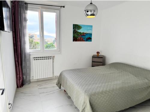 une chambre blanche avec un lit et une fenêtre dans l'établissement Spacious T3 in St-Raphaël, à Saint-Raphaël