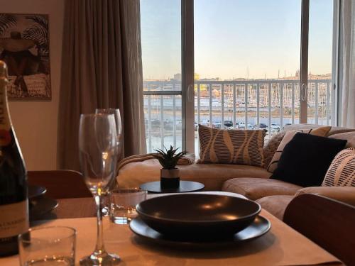 a living room with a couch and a table with wine glasses at Valletta and Sea Views Super Location in Il-Gżira
