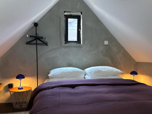 a bedroom with a large bed in a attic at THE L lodge, ocean view private garden Cottage in Ribeira Brava