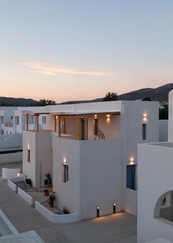 a white house with lights on the side of it at Malvia Beach House Naxos in Kastraki