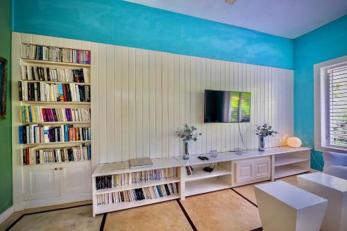 a living room with a table and book shelves with books at Villa Azulsalado - Frente a la playa in Las Terrenas