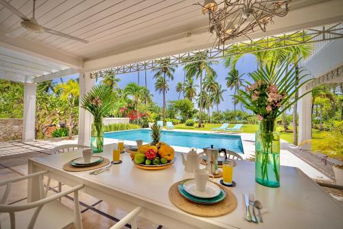 a dining room with a table and a pool at Villa Azulsalado - Frente a la playa in Las Terrenas