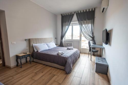 Un dormitorio con una cama y un televisor. en A peaceful & spacious apt near Vatican city, en Roma