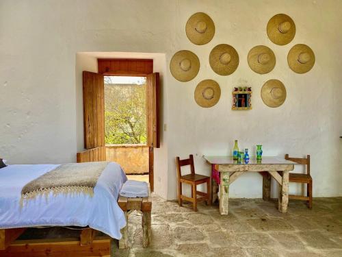 a bedroom with a bed and a table and a window at Hacienda Santa Barbara Casa Malinche in Huamantla