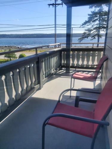 two chairs on a balcony looking out at the ocean at Heron's Landing Hotel in Campbell River