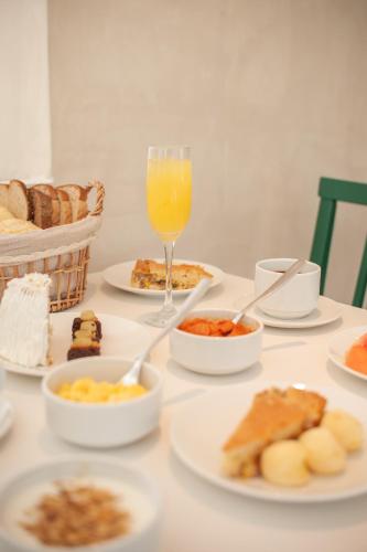 a table with plates of food and a glass of orange juice at Arraial Concept Hotel in Arraial do Cabo