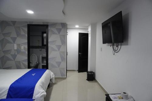 a bedroom with a bed and a flat screen tv at Hotel Ariston in Pasto