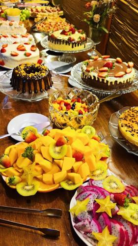 a table full of cakes and fruit on plates at Navega Hotéis in Navegantes