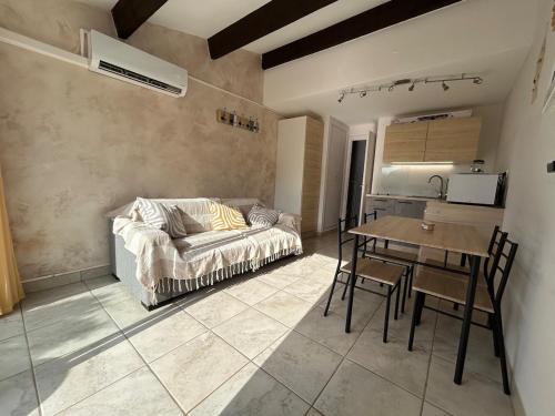 un salon avec un canapé et une table dans l'établissement Cap D Agde Roquille Clim 2 pers bord de mer, au Cap d'Agde