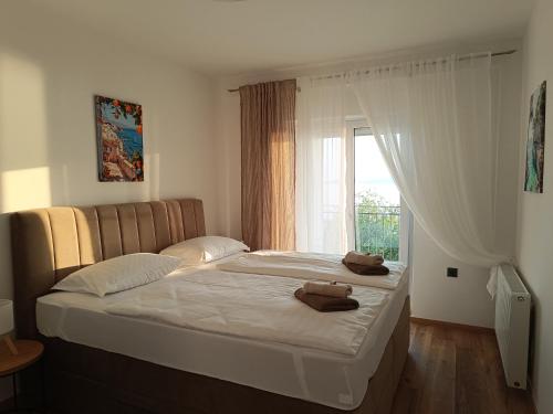 a bedroom with a large bed with towels on it at Apartmani Silvana&Vera in Senj
