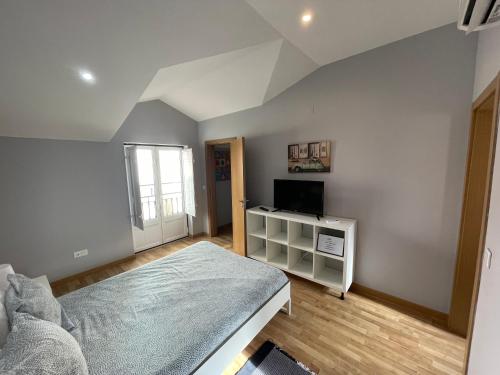 a bedroom with a bed and a television in it at Pateo Alfacinha in Lisbon
