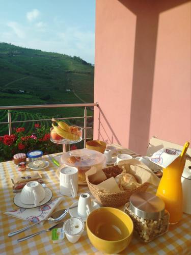 a table with breakfast food on a table with a view at Quinta de Baixo in Vila Marim