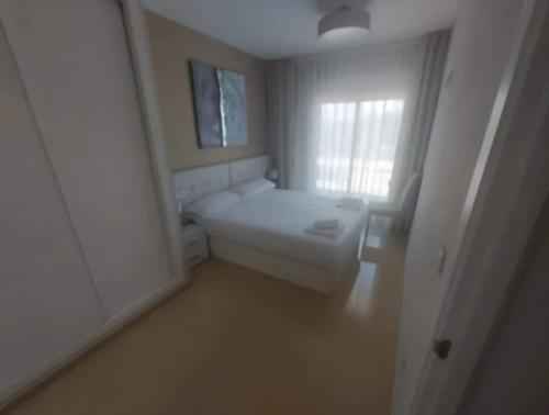 Cette petite chambre blanche dispose d'une fenêtre et d'un canapé. dans l'établissement Costa Azahar - En Primera Línea, à El Borseral