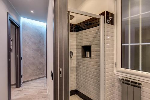 La salle de bains est pourvue d'une douche avec une porte en verre. dans l'établissement Lux Apartment, à Rome