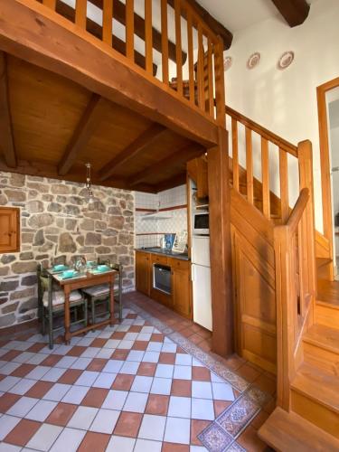 une cuisine avec un escalier en bois et une table dans l'établissement Gîte Lou Clapas dans village perché du Parc des Grands Causses, à Nant