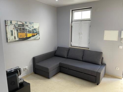 a living room with a couch and a window at Pateo Alfacinha in Lisbon