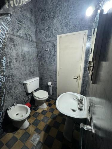 a bathroom with a toilet and a sink at Casa BUENOS AIRES in Villa María