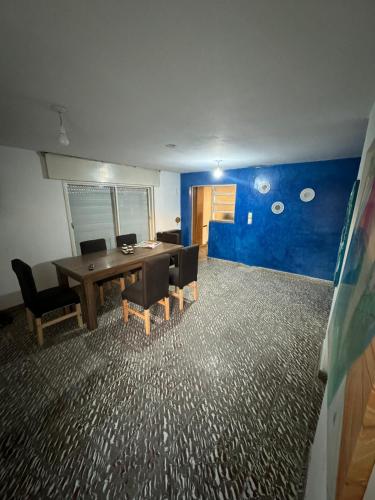 a room with a table and chairs and a blue wall at Casa BUENOS AIRES in Villa María