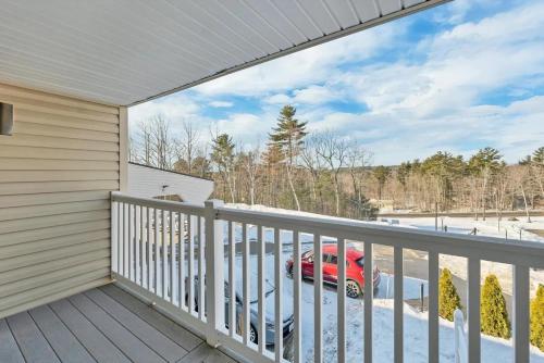 a house with a balcony with a car parked on it at Cedar Lodge Room-Private Balcony Close to Weirs! in Laconia
