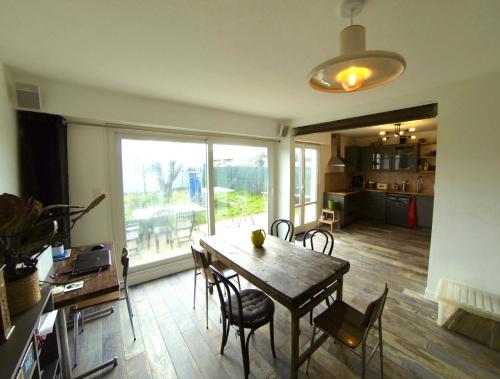 une salle à manger avec une table et des chaises et une cuisine dans l'établissement Chambre proche de l'Ile de Ré, à La Rochelle
