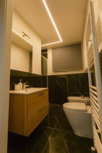 a bathroom with a sink toilet and a mirror at La Dimora degli Artisti in Pescara