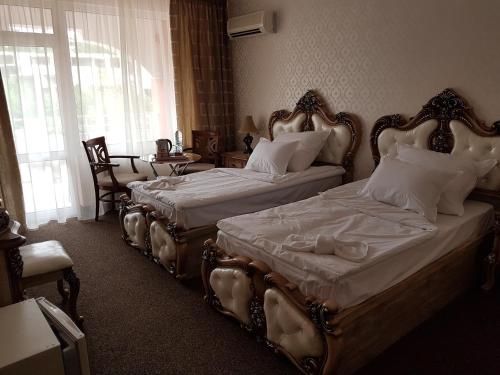 two beds sitting next to each other in a bedroom at Hotel Elit Palace and SPA in Balchik
