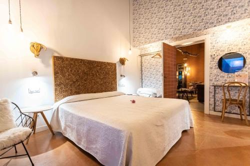 a bedroom with a white bed in a room at Niditas Suites & Horses in Santillana del Mar