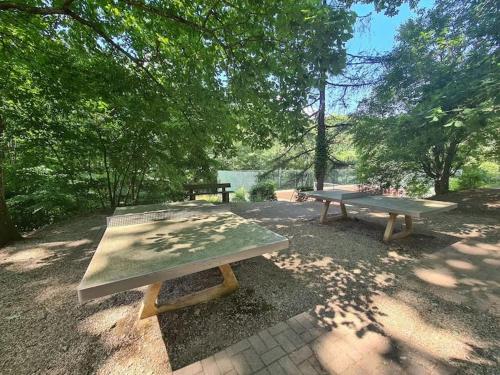 two picnic tables in a park under a tree at Appartement studio in Boersch